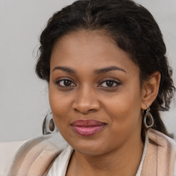 Joyful black young-adult female with long  brown hair and brown eyes