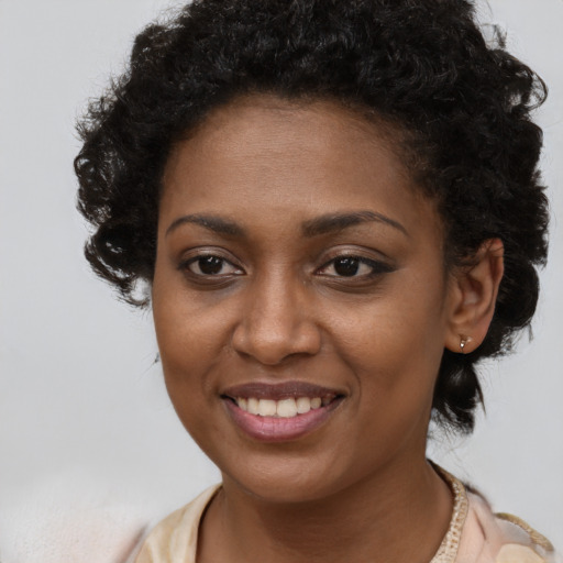 Joyful black young-adult female with short  brown hair and brown eyes