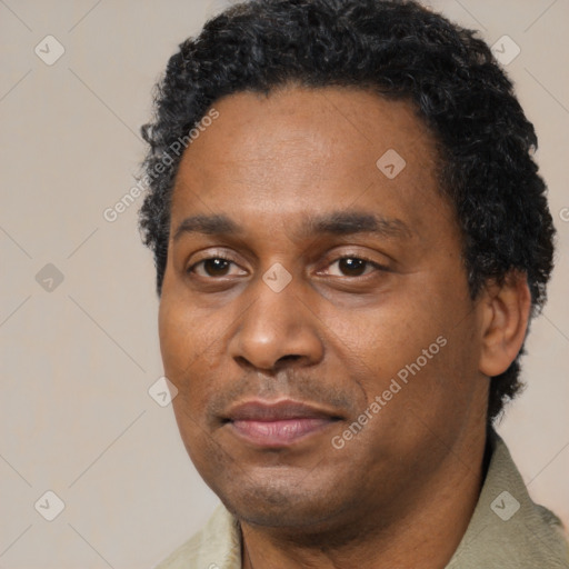 Joyful black adult male with short  black hair and brown eyes