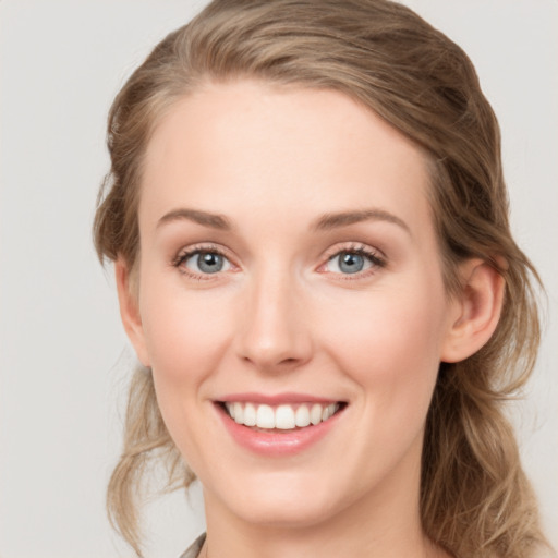 Joyful white young-adult female with medium  brown hair and blue eyes