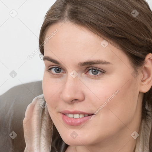 Joyful white young-adult female with long  brown hair and grey eyes