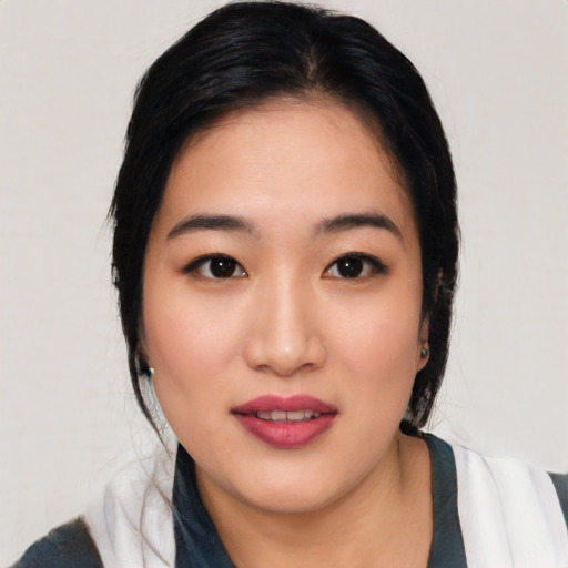 Joyful asian young-adult female with medium  black hair and brown eyes