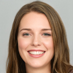 Joyful white young-adult female with long  brown hair and green eyes