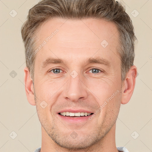 Joyful white adult male with short  brown hair and grey eyes