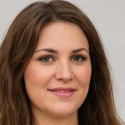 Joyful white young-adult female with long  brown hair and green eyes