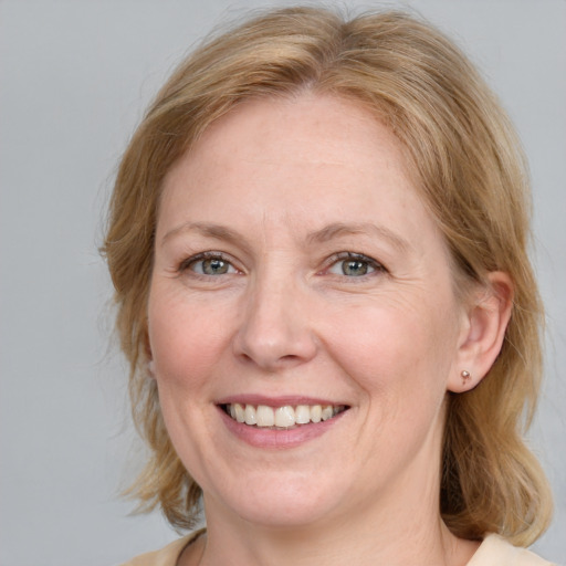 Joyful white adult female with medium  brown hair and blue eyes