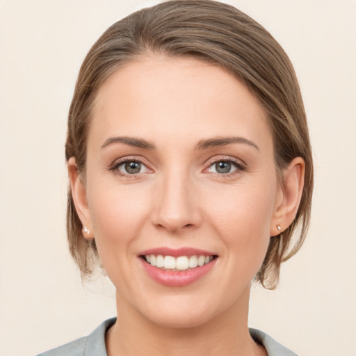 Joyful white young-adult female with medium  brown hair and grey eyes