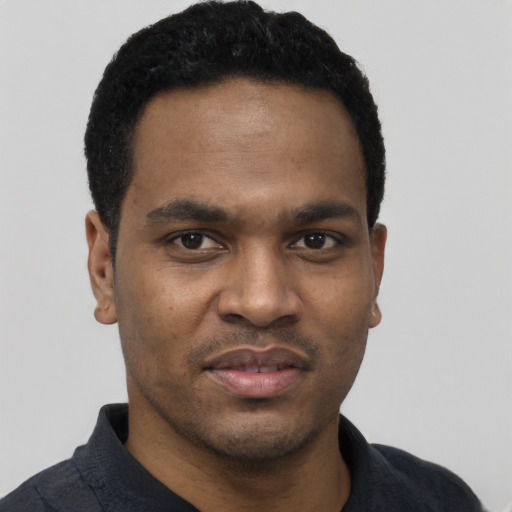 Joyful black young-adult male with short  black hair and brown eyes