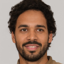 Joyful latino young-adult male with short  brown hair and brown eyes