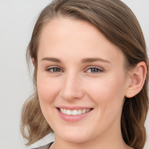 Joyful white young-adult female with medium  brown hair and blue eyes