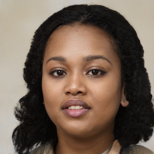 Joyful black young-adult female with long  black hair and brown eyes