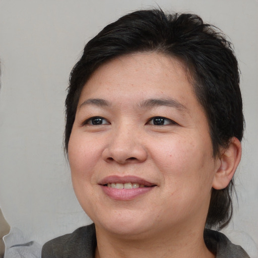 Joyful asian adult female with medium  brown hair and brown eyes