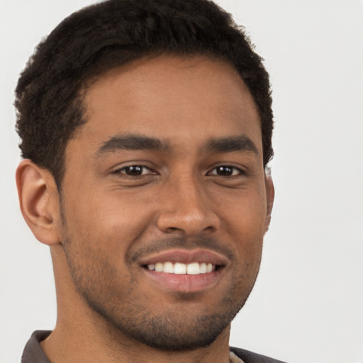 Joyful black young-adult male with short  brown hair and brown eyes