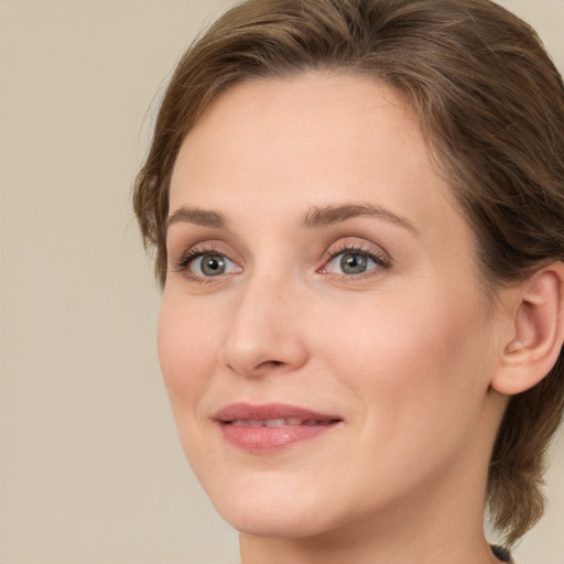 Joyful white young-adult female with medium  brown hair and green eyes