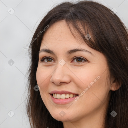 Joyful white young-adult female with long  brown hair and brown eyes