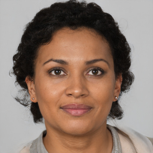 Joyful black adult female with medium  brown hair and brown eyes