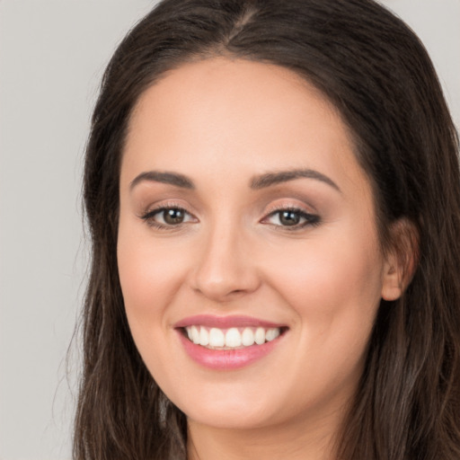 Joyful white young-adult female with long  brown hair and brown eyes