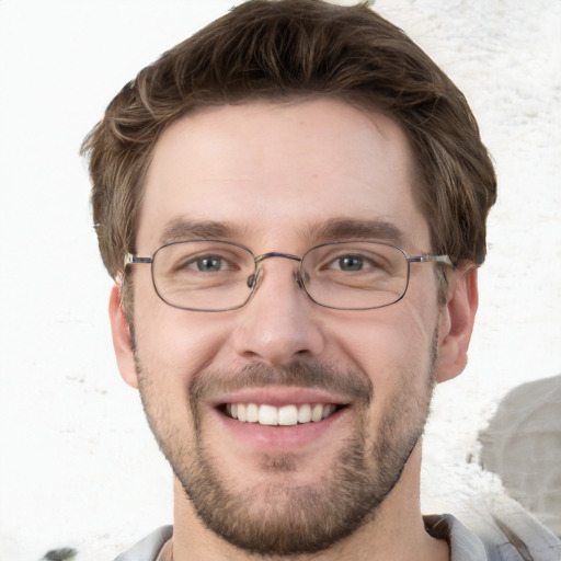 Joyful white young-adult male with short  brown hair and grey eyes