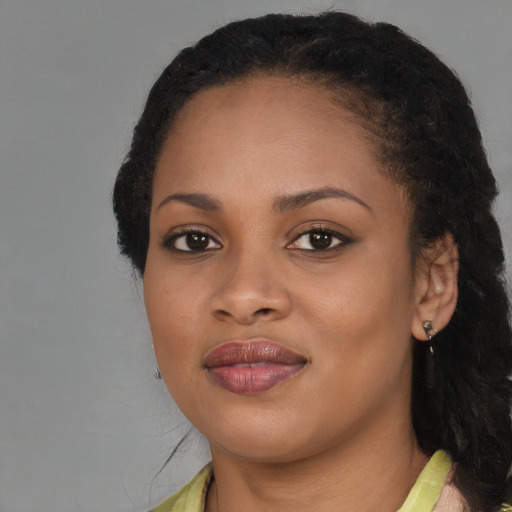 Joyful black young-adult female with long  brown hair and brown eyes