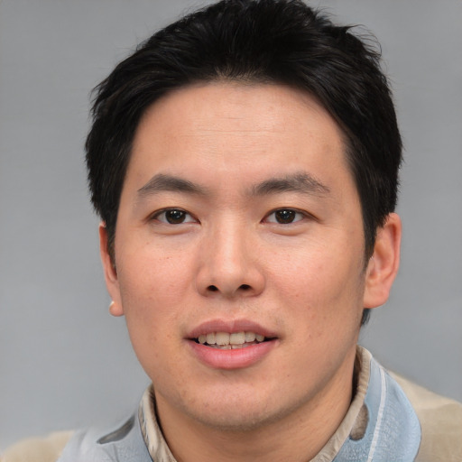 Joyful asian young-adult male with short  brown hair and brown eyes