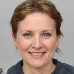 Joyful white adult female with medium  brown hair and blue eyes