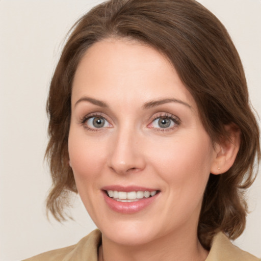 Joyful white young-adult female with medium  brown hair and grey eyes