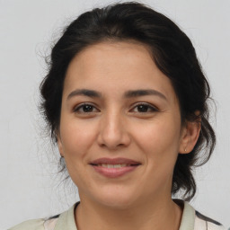 Joyful latino young-adult female with medium  brown hair and brown eyes