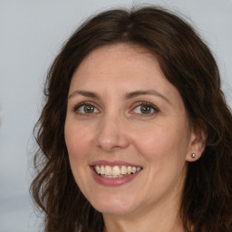 Joyful white adult female with long  brown hair and brown eyes