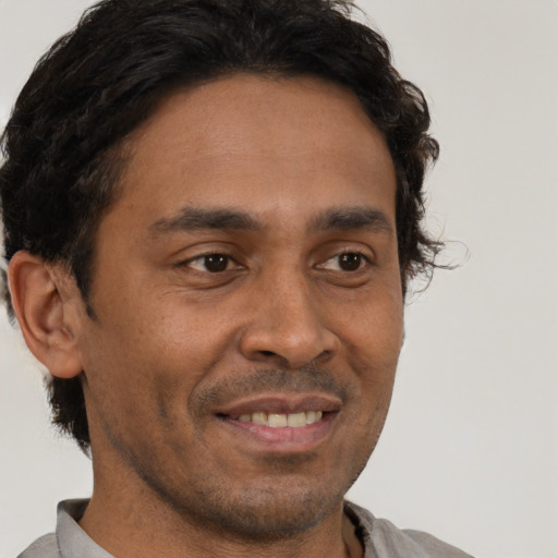 Joyful latino young-adult male with short  brown hair and brown eyes