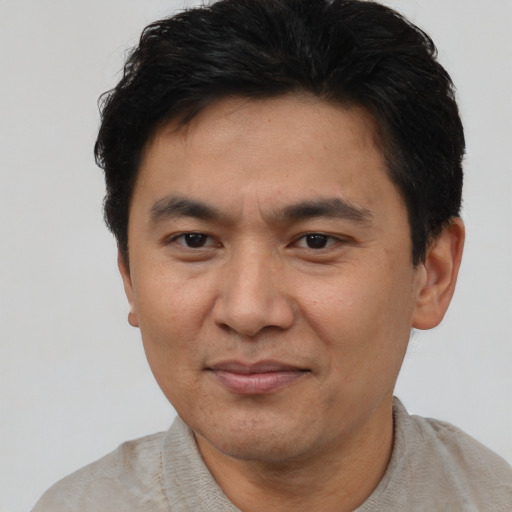 Joyful asian adult male with short  brown hair and brown eyes