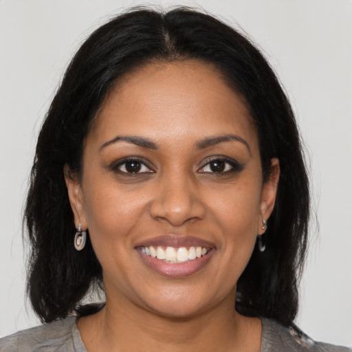 Joyful black young-adult female with medium  brown hair and brown eyes