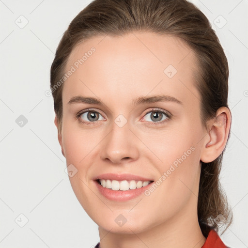 Joyful white young-adult female with medium  brown hair and grey eyes