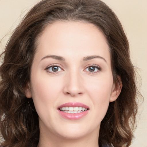 Joyful white young-adult female with long  brown hair and green eyes