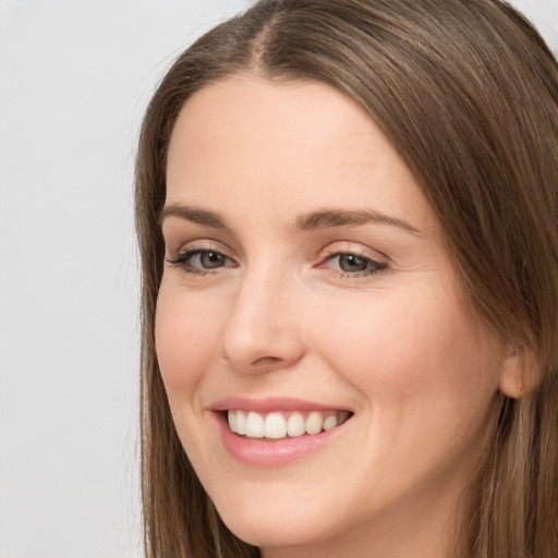 Joyful white young-adult female with long  brown hair and grey eyes