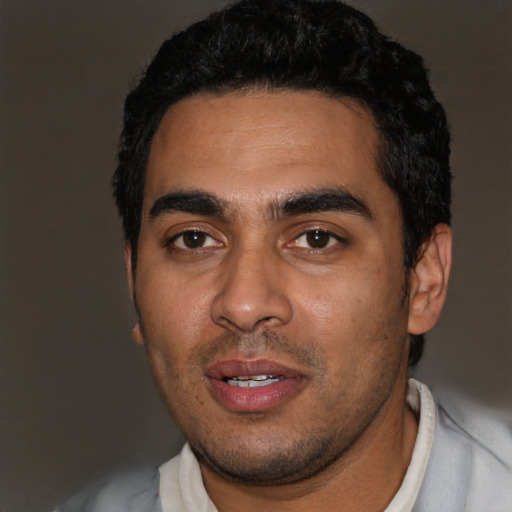 Joyful latino young-adult male with short  black hair and brown eyes
