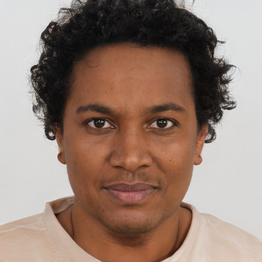 Joyful black young-adult male with short  brown hair and brown eyes