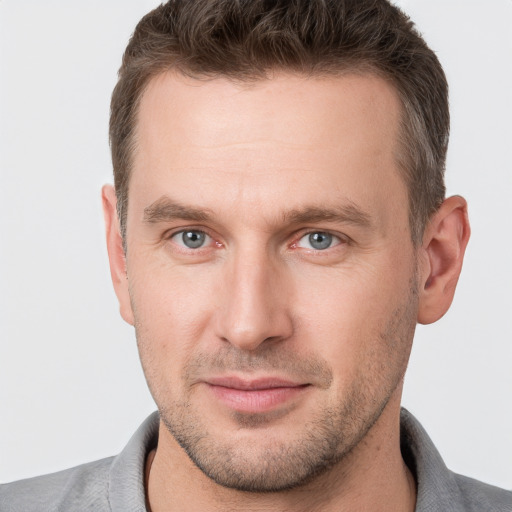 Joyful white young-adult male with short  brown hair and grey eyes