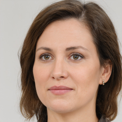 Joyful white young-adult female with medium  brown hair and green eyes