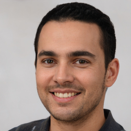 Joyful white young-adult male with short  black hair and brown eyes