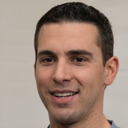 Joyful white young-adult male with short  black hair and brown eyes