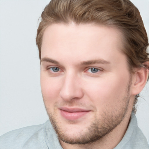 Joyful white young-adult male with short  brown hair and blue eyes