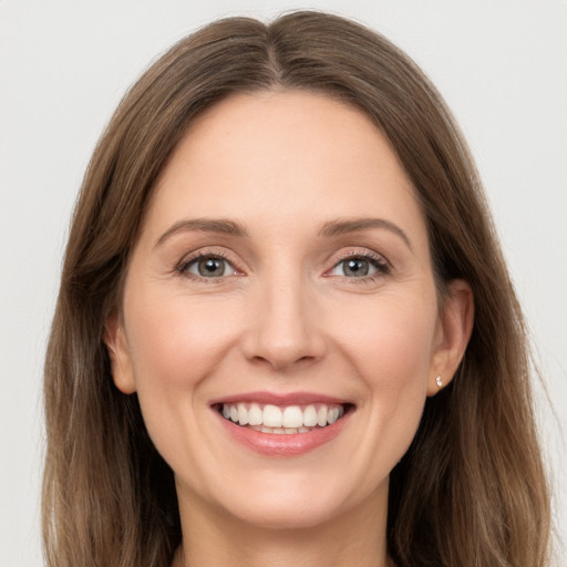 Joyful white young-adult female with long  brown hair and grey eyes