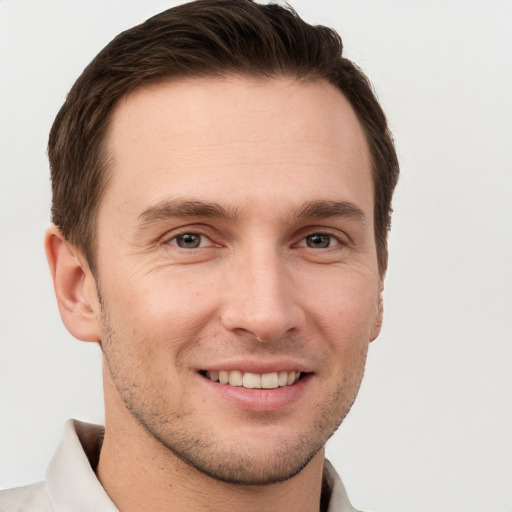 Joyful white young-adult male with short  brown hair and grey eyes