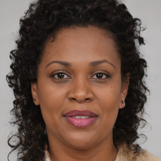 Joyful black adult female with long  brown hair and brown eyes