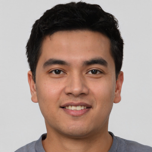 Joyful asian young-adult male with short  black hair and brown eyes