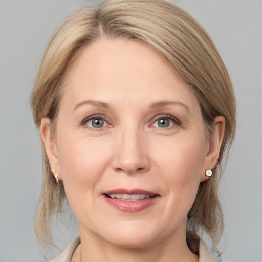 Joyful white adult female with medium  brown hair and grey eyes