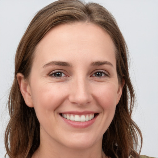 Joyful white young-adult female with long  brown hair and grey eyes