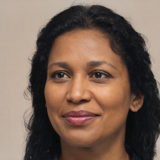 Joyful black adult female with long  brown hair and brown eyes