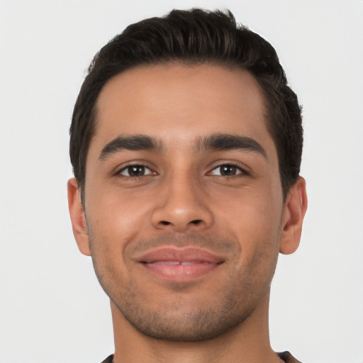 Joyful latino young-adult male with short  brown hair and brown eyes