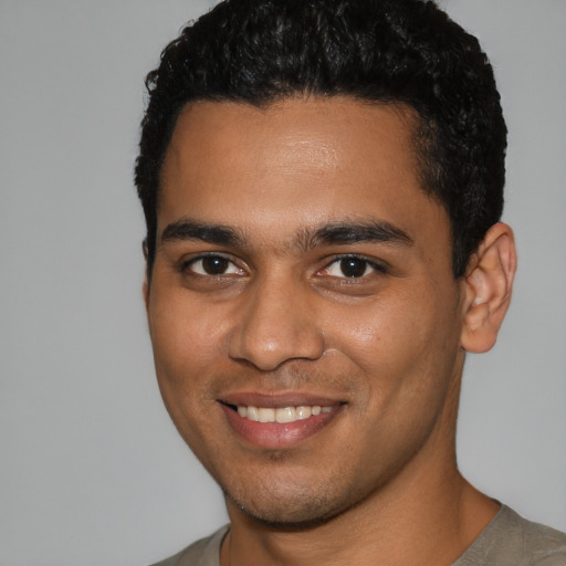 Joyful latino young-adult male with short  brown hair and brown eyes